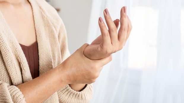 woman suffering from wrist pain, numbness, or Carpal tunnel syndrome hand holding her ache joint