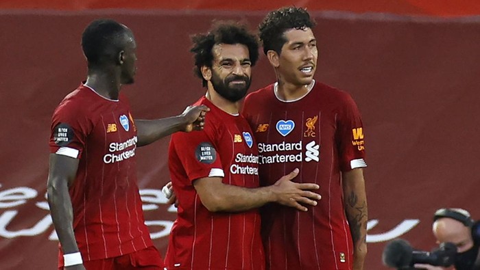 Liverpools Egyptian midfielder Mohamed Salah (C) celebrates scoring his teams second goal with Liverpools Senegalese striker Sadio Mane (L) and Liverpools Brazilian midfielder Roberto Firmino during the English Premier League football match between Liverpool and Crystal Palace at Anfield in Liverpool, north west England on June 24, 2020. (Photo by PHIL NOBLE / POOL / AFP) / RESTRICTED TO EDITORIAL USE. No use with unauthorized audio, video, data, fixture lists, club/league logos or live services. Online in-match use limited to 120 images. An additional 40 images may be used in extra time. No video emulation. Social media in-match use limited to 120 images. An additional 40 images may be used in extra time. No use in betting publications, games or single club/league/player publications. /  (Photo by PHIL NOBLE/POOL/AFP via Getty Images)