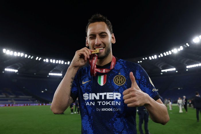 ROME, ITALY - MAY 11: Hakan Calhanoglu of FC Internazionale bites his winners medal as he celebrates following the 4-2 victory in the Coppa Italia Final match between Juventus and FC Internazionale at Stadio Olimpico on May 11, 2022 in Rome, Italy. (Photo by Jonathan Moscrop/Getty Images)