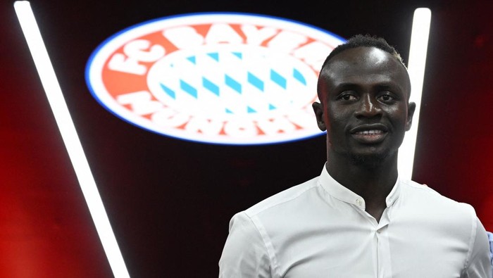 Sadio Mane Bayern Munich's Senegalese new forward Sadio Mane poses in front of the Bayern Munich logo during a press conference after he signed a three-year deal with German first division football club FC Bayern Munich, in Munich, southern Germany, on June 22, 2022. - Bayern Munich confirmed the signing of Sadio Mane from Liverpool on June 22, as the Senegal forward signed a three-year deal with the Bundesliga champions. Bayern have reportedly paid a fee which could rise to 41 million euros (USD 43 million) for Mane. (Photo by CHRISTOF STACHE / AFP) (Photo by CHRISTOF STACHE/AFP via Getty Images)