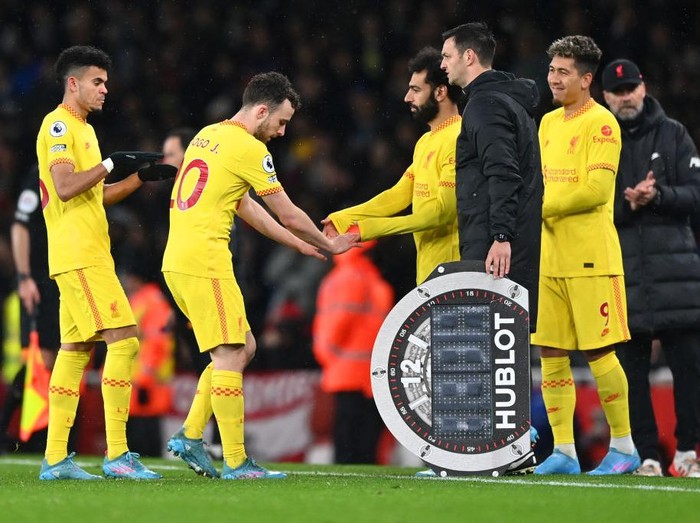 LONDON, ENGLAND - MARCH 16: Roberto Firmino and Mohamed Salah of Liverpool prepare to be substituted onto the pitch to replace team mates Diogo Jota and Luis Diaz during the Premier League match between Arsenal and Liverpool at Emirates Stadium on March 16, 2022 in London, England. (Photo by Shaun Botterill/Getty Images)