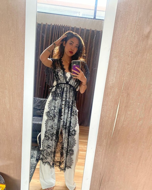 Lingerie yang biasa digunakna untuk tidur dijadikan sebagai outer dengan jumpsuit putih. Look seperti ini bisa dijadikan untuk hangout atau kencan.