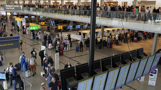 FILE - Travelers wait in long lines to check in and board flights at Amsterdam's Schiphol Airport, Netherlands, Tuesday, June 21, 2022. (AP Photo/Peter Dejong, File)