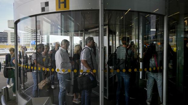 FILE - Travelers wait in long lines to check in and board flights at Amsterdam's Schiphol Airport, Netherlands, Tuesday, June 21, 2022. (AP Photo/Peter Dejong, File)