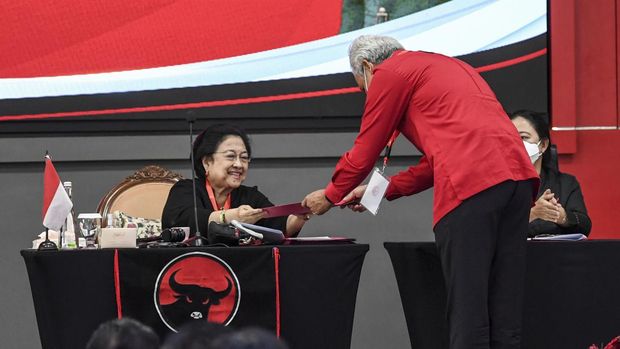 Kader Partai Demokrasi Indonesia Perjuangan (PDIP) yang juga Gubernur Jawa Tengah Ganjar Pranowo (tengah) memberikan naskah rekomendasi eksternal kepada Ketua Umum PDIP Megawati Soekarnoputri (kiri) disaksikan Ketua DPP Bidang Politik Puan Maharani (kanan) saat Penutupan Rakernas II PDIP di Sekolah Partai, Lenteng Agung, Jakarta, Rabu (23/6/2022).Dalam Rakernas II PDIP tersebut menghasilkan empat rekomendasi eksternal yaitu Ideologi Pancasila, Sistem Politik dan Pemilu 2024, Pembangunan Desa, Pemenangan Pemilu, dan Agenda Startegis Partai. ANTARA FOTO/M Risyal Hidayat/YU