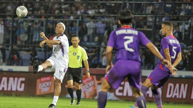 Mantan pesepak bola dunia asal Brazil Ronaldinho (tengah) mengoper bola dengan dihadang pesepak bola Persik Kediri Arthur Irawan (kedua kiri) saat pertandingan Trofeo Ronaldinho di Stadion Kanjuruhan, Malang, Jawa Timur, Minggu (26/6/2022). Ronaldinho memperkuat tim RANS Nusantara FC dalam trofeo yang diikuti Arema FC dan Persik Kediri dalam rangkaian kunjungannya di Malang. ANTARA FOTO/Rizal Hanafi/Ds/aww.