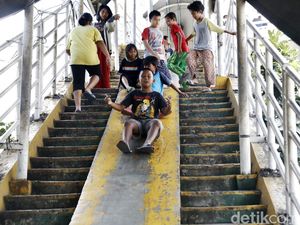 Senyum Ceria Anak-anak Main Perosotan di JPO