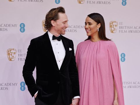 British actor Tom Hiddleston (L) and British actress Zawe Ashton pose on the red carpet upon arrival at the BAFTA British Academy Film Awards at the Royal Albert Hall, in London, on March 13, 2022. (Photo by Tolga Akmen / AFP)
