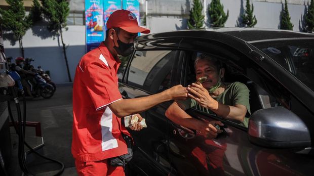 Petugas SPBU memberikan panduan kepada seorang pengendara untuk pengisian BBM melalui aplikasi MyPertamina di Bandung, Jawa Barat, Jumat (1/7/2022).  Pertamina Patra Niaga mulai hari ini menerapkan uji coba cara baru pembelian Pertalite dan Solar menggunakan aplikasi MyPertamina pada kendaraan roda empat di 11 daerah di lima provinsi di Indonesia. ANTARA FOTO/Raisan Al Farisi/rwa.