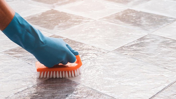 Ilustrasi Membersihkan Kamar Mandi Hand of man wearing blue rubber gloves is used to convert scrub cleaning on the tile floor.