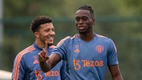 Entah apa yang dibahas Jadon Sancho dan Aaron Wan-Bissaka, tapi keduanya tampak ceria. Foto: Manchester United via Getty Imag/Ash Donelon