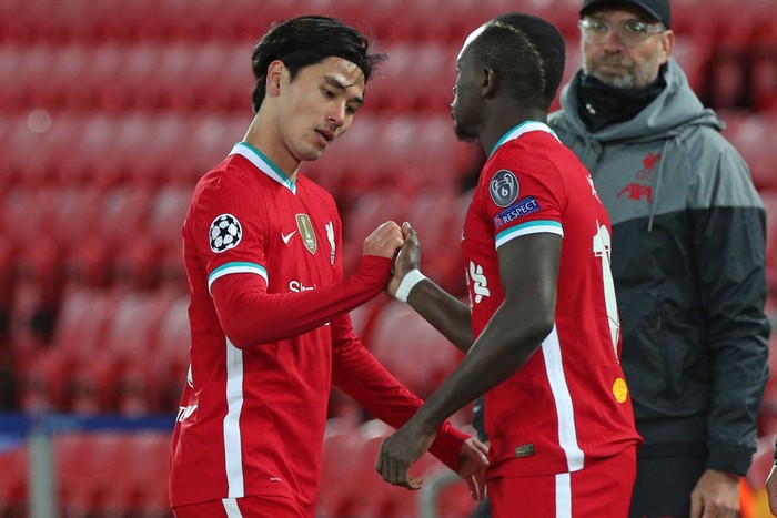 Liverpool's Japanese midfielder Takumi Minamino (L) gestures with Liverpool's Senegalese striker Sadio Mane as he is replaced during the UEFA Champions league Group D football match between Liverpool and Midtjylland at Anfield in Liverpool, north west England on October 27, 2020. (Photo by Peter Byrne / POOL / AFP) (Photo by PETER BYRNE/POOL/AFP via Getty Images)