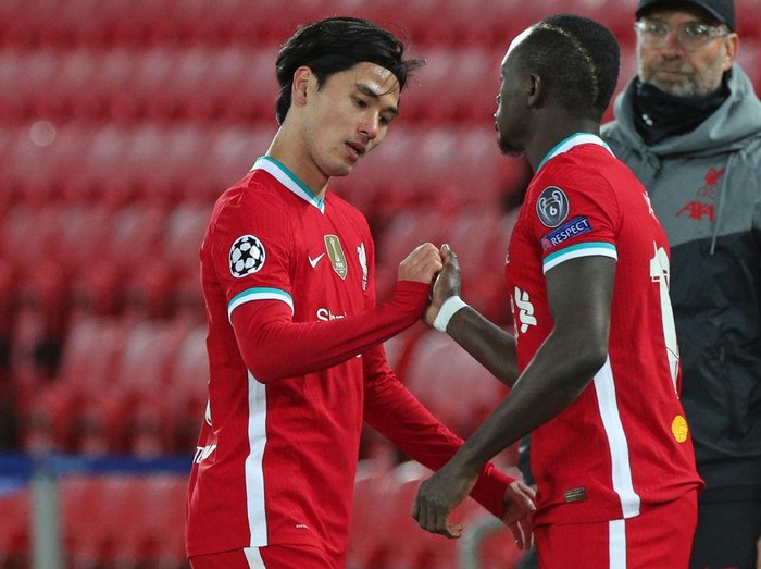 Liverpool's Japanese midfielder Takumi Minamino (L) gestures with Liverpool's Senegalese striker Sadio Mane as he is replaced during the UEFA Champions league Group D football match between Liverpool and Midtjylland at Anfield in Liverpool, north west England on October 27, 2020. (Photo by Peter Byrne / POOL / AFP) (Photo by PETER BYRNE/POOL/AFP via Getty Images)