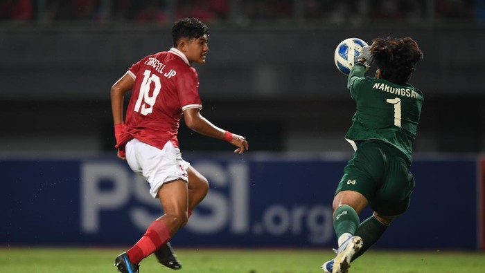 Pesepak bola Indonesia U19 Marcell Januar Putra (kiri) mencoba menaklukkan kiper Thailand U19 Narongsak Naengwongsa (kanan)  dalam laga penyisihan grup Piala AFF U19 di Stadion Patriot Candrabhaga, Bekasi, Jawa Barat, Rabu (6/7/2022). ANTARA FOTO/Akbar Nugroho Gumay/foc.