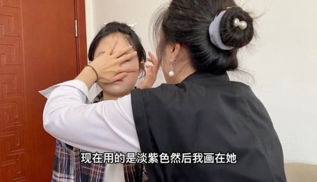 Xiao Jia tengah merias wajah kliennya