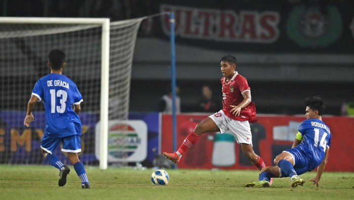 Pesepak bola Tim Nasional Indonesia U-19 Razzaa Fachrezi (tengah) mengecoh pesepak bola Tim Nasional Filipina U-19 Jaime Domingo (kanan) dalam laga penyisihan Grup A Piala AFF U-19 2022 di Stadion Patriot Candrabhaga, Bekasi, Jawa Barat, Jumat (8/7/2022). Indonesia memenangkan pertandingan tersebut dengan skor 5-1. ANTARA FOTO/Aditya Pradana Putra/aww.
