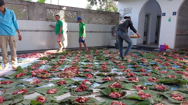 Warga Depok bagikan daging kurban menggunakan daun jati untuk mengurangi sampah plastik.