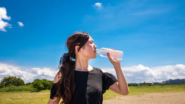 Ilustrasi wanita minum dalam cuaca panas