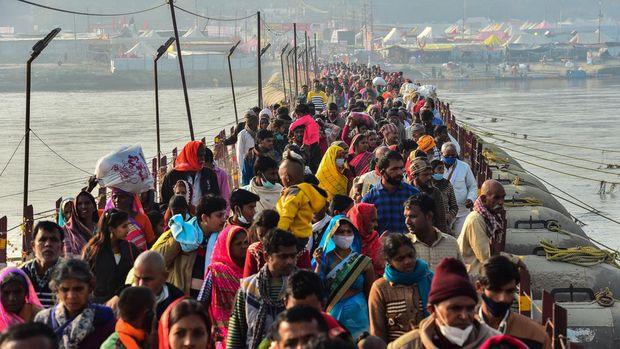 Populasi India Bakal Kalahkan China Pada 2023 Hindu devotees arrive to take a holy dip at the Sangam, the confluence of the rivers Ganges and Yamuna and mythical Saraswati, on the eve of the auspicious bathing day of 'Mauni Amavasya' during the annual Magh Mela festival in Allahabad, on January 31, 2022. (Photo by SANJAY KANOJIA / AFP)