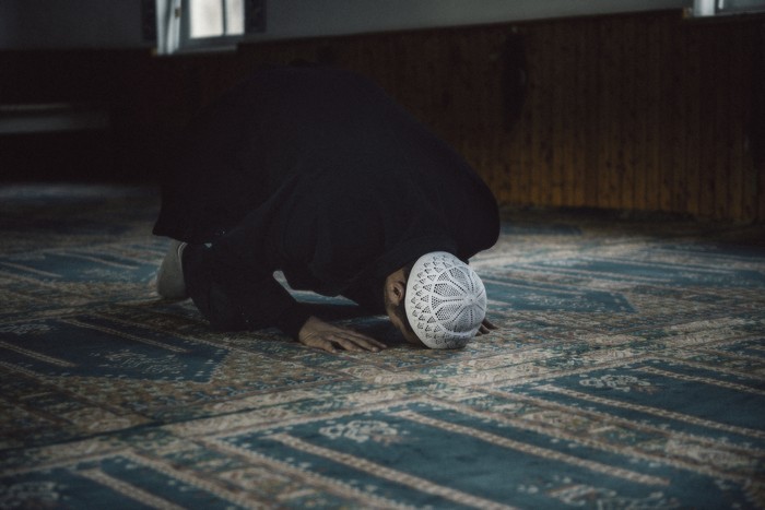 1216443155 Shot of a Muslim young man worshiping in a mosque.