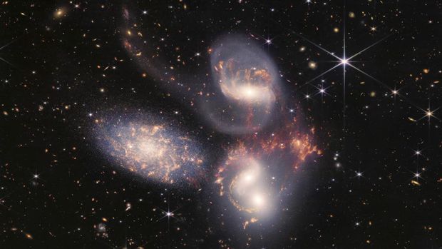 A group of five galaxies that appear close to each other in the sky: two in the middle, one toward the top, one to the upper left, and one toward the bottom are seen in a mosaic or composite of near and mid-infrared data from NASA's James Webb Space Telescope, a revolutionary apparatus designed to peer through the cosmos to the dawn of the universe and released July 12, 2022.    NASA, ESA, CSA, STScI, Webb ERO Production Team/Handout via REUTERS
<div class='mb-4'></div>THIS IMAGE HAS BEEN SUPPLIED BY A THIRD PARTY.