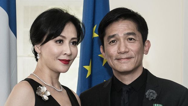 Hong Kong actor Tony Leung poses with his wife Carina Lau after receiving the distinction of 