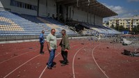 Pegawai stadion melihat bagian stadion yang rusak.