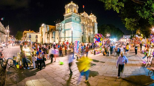 Oaxaca, Mexico - February 22, 2014: View of people walking around the lively facade of Cathedral of Our Lady of the Assumption (Catedral de Oaxaca) in Oaxaca, Mexico.