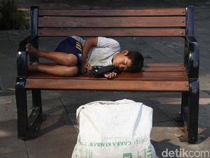 Lelah Memulung, Bocah Ini Tertidur Pulas di Kursi Trotoar