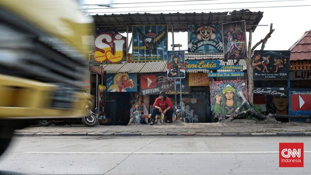 Jamari (40-an) melukis dengan media truck, mini bus dan kendaraan roda empat kecil lainnya dari tahun 1996, yang diawali dengan teknik kuas lalu ke airbrush. (CNN Indonesia/Andry Novelino)