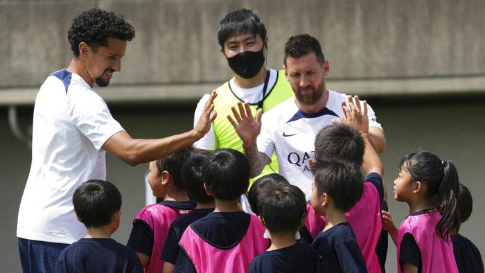 Paris Saint-Germain soccer players, from left, Sergio Ramos, Lionel Messi, Neymar, coach Christophe Galtier, Kylian Mbappe and Marquinhos meet children during a PSG soccer lesson Monday, July 18, 2022, in Tokyo. Paris Saint-Germain is in Japan for their pre-season tour and will play three friendly matches against Japan's J1 League teams. (AP Photo/Eugene Hoshiko)
