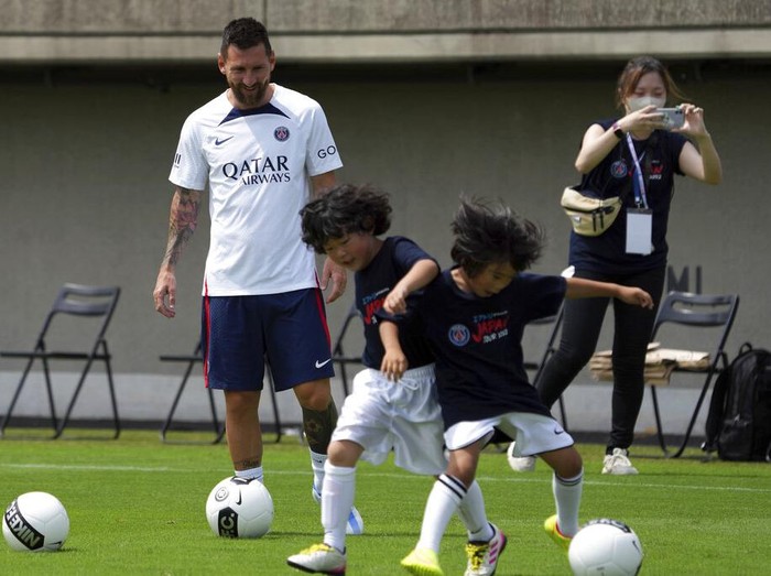 Paris Saint-Germain soccer players, from left, Sergio Ramos, Lionel Messi, Neymar, coach Christophe Galtier, Kylian Mbappe and Marquinhos meet children during a PSG soccer lesson Monday, July 18, 2022, in Tokyo. Paris Saint-Germain is in Japan for their pre-season tour and will play three friendly matches against Japan's J1 League teams. (AP Photo/Eugene Hoshiko)