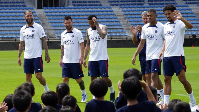 Paris Saint-Germain soccer players, from left, Sergio Ramos, Lionel Messi, Neymar, coach Christophe Galtier, Kylian Mbappe and Marquinhos meet children during a PSG soccer lesson Monday, July 18, 2022, in Tokyo. Paris Saint-Germain is in Japan for their pre-season tour and will play three friendly matches against Japan's J1 League teams. (AP Photo/Eugene Hoshiko)