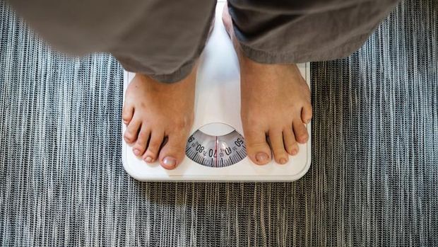 Ilustrasi perempuan menimbang berat badan