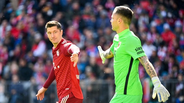 09 April 2022, Bavaria, Munich: Soccer: Bundesliga, Bayern Munich - FC Augsburg, Matchday 29, Allianz. Munichs Robert Lewandowski and Augsburg goalkeeper Rafal Gikiewicz high-five each other. Photo: Sven Hoppe/dpa (Photo by Sven Hoppe/picture alliance via Getty Images)