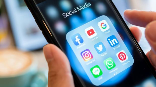 BANGKOK, THAILAND- 26 June 2019 : Hands of man use Iphone 7 plus with social media application of facebook, youtube, google search, instagram, twitter, linked in, line whatsapp, and pinterest on black background