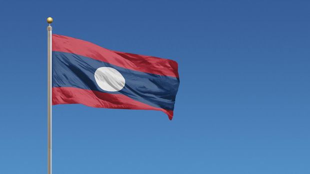 Flag of Laos in front of a clear blue sky