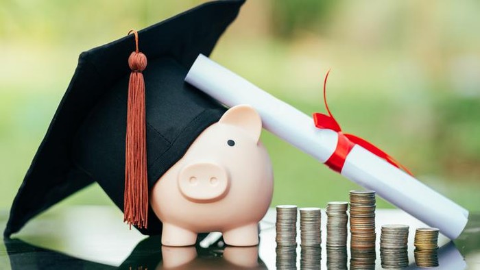 ilustrasi ongkos kuliah piggy bank With Graduation Cap on black glass floor,Money saving concept.