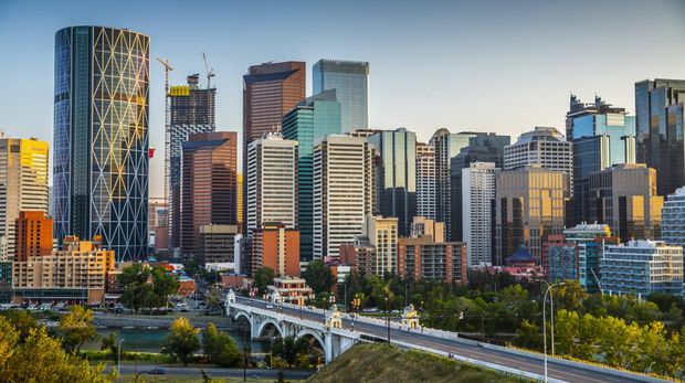 Calgarys skyline with its skyscrapers and office buildings. Bow river and centre Street Bridge in the foreground. Alberta - Canada