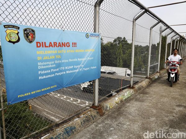 Spanduk Larangan Melempar Batu ke Jalan Tol JORR