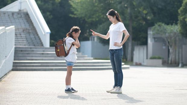A woman scolding an elementary school student