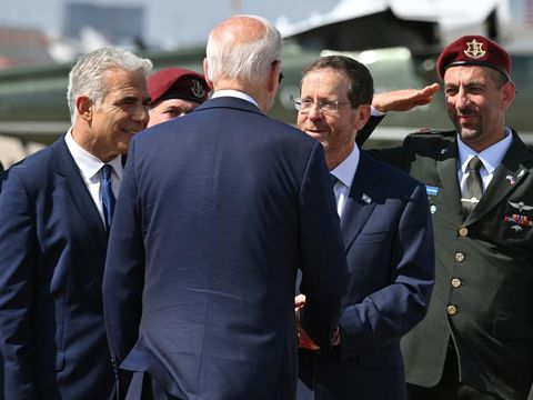 Israeli Brigadier General Ala Abu Rokun (R), Druze officer who is military secretary to the Israeli president, gives a salute while US President Joe Biden (C) is bid farewell by Israel's President Isaac Herzog (2nd-R) and caretaker Prime Minister Yair Lapid (R) at Ben Gurion Airport on July 15, 2022. - Biden is travelling to Saudi Arabia after two-day visit to Israel. (Photo by MANDEL NGAN / AFP)