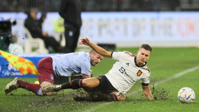 TOPSHOT - John McGinn of Aston Villa (L) and Manchester United player Diogo Dalot slide during a friendly match between Manchester United and Aston Villa at Optus Stadium in Perth on July 23, 2022. - -- IMAGE RESTRICTED TO EDITORIAL USE - STRICTLY NO COMMERCIAL USE -- (Photo by Trevor Collens / AFP) / -- IMAGE RESTRICTED TO EDITORIAL USE - STRICTLY NO COMMERCIAL USE -- (Photo by TREVOR COLLENS/AFP via Getty Images)