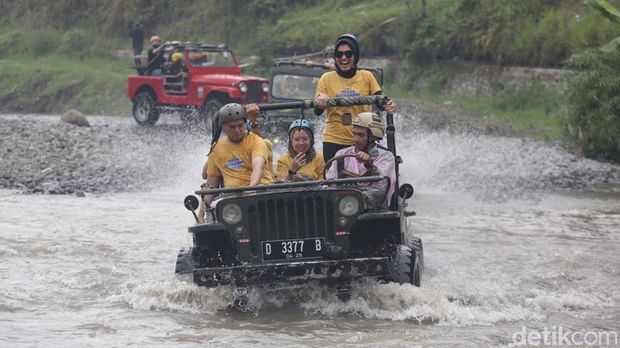 Wisatawan menggunakan mobil Jip ketika mengikuti wisata