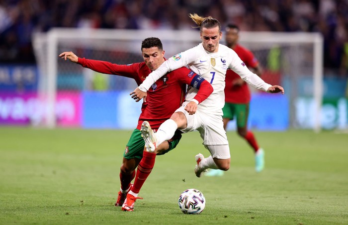 BUDAPEST, HUNGARY - JUNE 23: Cristiano Ronaldo of Portugal battles for possession with Antoine Griezmann of France during the UEFA Euro 2020 Championship Group F match between Portugal and France at Puskas Arena on June 23, 2021 in Budapest, Hungary. (Photo by Alex Pantling/Getty Images)