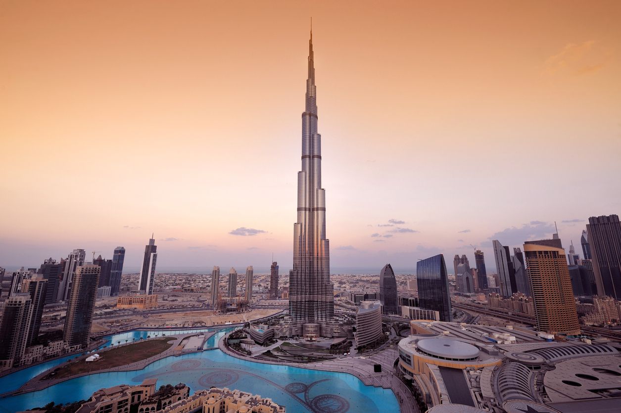 A panoramic view of the Dubai city skyline with the Burj Khalifa shown in the center.  The Burj Khalifa is the tallest building in the world.