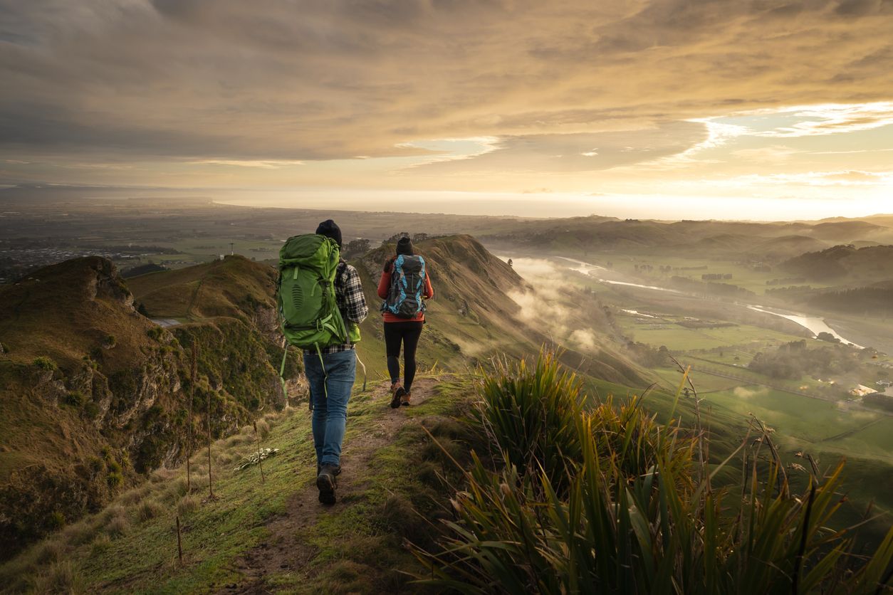Backpackers walking on a mountain during sunrise. Te Mata Peak, Hawke´s Bay, New Zealand.