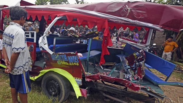 Warga melihat odong-odong yang ringsek tertabrak kereta api jurusan Merak-Rangkasbitung di Kampung Silebu Mesjid, Kragilan, Serang, Banten, Selasa (26/7/2022). Insiden yang terjadi di perlintasan tanpa palang pintu tersebut menewaskan sembilan orang penumpang odong-odong, yang terdiri dari tujuh orang dewasa dan dua anak-anak. ANTARA FOTO/Asep Fathulrahman/rwa.