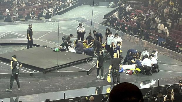 CORRECTS DATE - Two dancers receive medical treatment at a concert of Cantopop boy band Mirror, in Hong Kong, Thursday, July 28, 2022. Two dancers were injured at a Cantopop concert in Hong Kong after a massive video screen suspended above the stage fell onto performers below. (AP Photo)