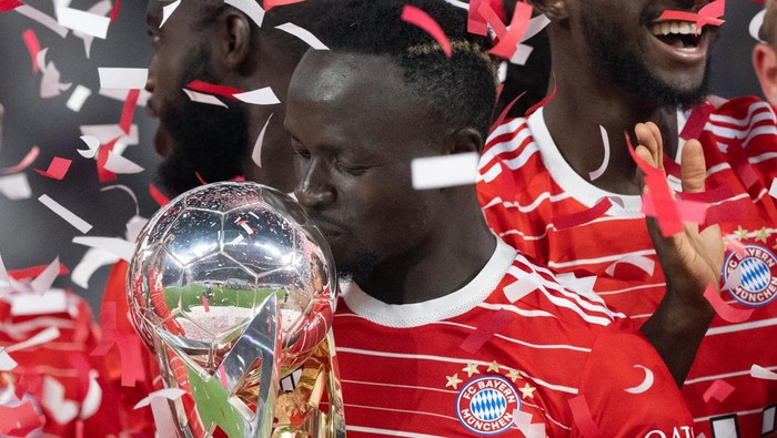 30 July 2022, Saxony, Leipzig: Soccer: DFL Supercup, RB Leipzig - Bayern Munich, Red Bull Arena. Bayerns Sadio Mane kisses the cup. Photo: Hendrik Schmidt/dpa - IMPORTANT NOTE: In accordance with the requirements of the DFL Deutsche Fußball Liga and the DFB Deutscher Fußball-Bund, it is prohibited to use or have used photographs taken in the stadium and/or of the match in the form of sequence pictures and/or video-like photo series. (Photo by Hendrik Schmidt/picture alliance via Getty Images)